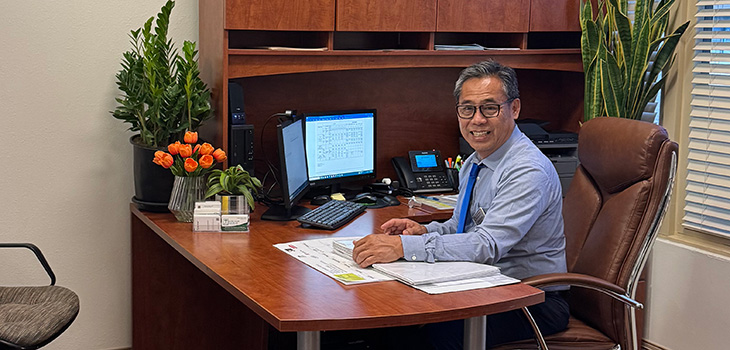 The Administrator, Nestor Alegre sitting at his desk at Pacific Palms