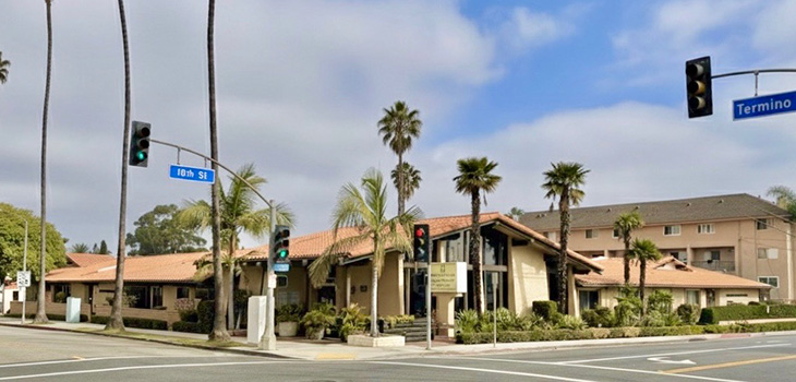 Street view of Pacific Palms with monument sign and palm trees