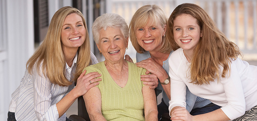 A family outside smiling together in a group.