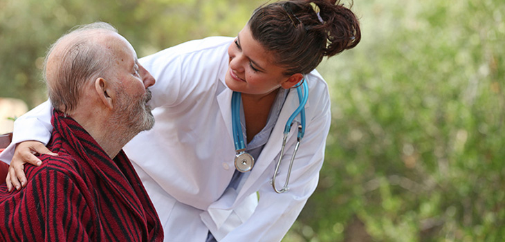 doctor leaning down to speak with a resident