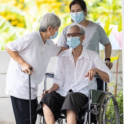 Lone Tree employee assisting elderly couple with cane and wheelchair