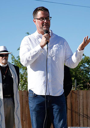 Pastor Matthew Smith delivers a blessing at a local Habitat for Humanity event.