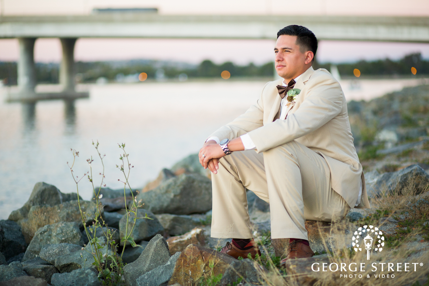sunset wedding portrait of groom by water