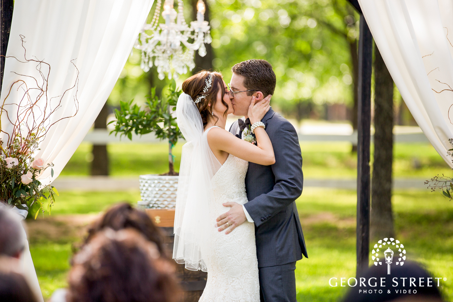 bride and groom sunny outdoor wedding ceremony first kiss