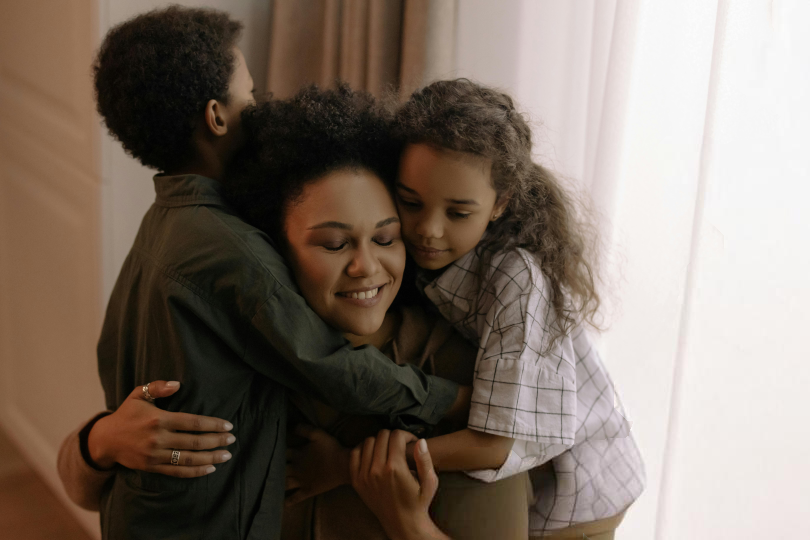 Woman hugging her two children