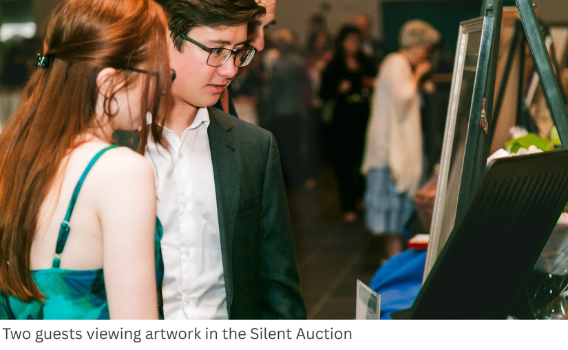 Two guests viewing artwork in the Silent Auction