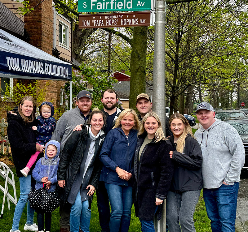 Hopkins.jpg The family of Tom Hopkins stand below a street sign that says Honorary Tom 'Papa Hops' Hopkins Way