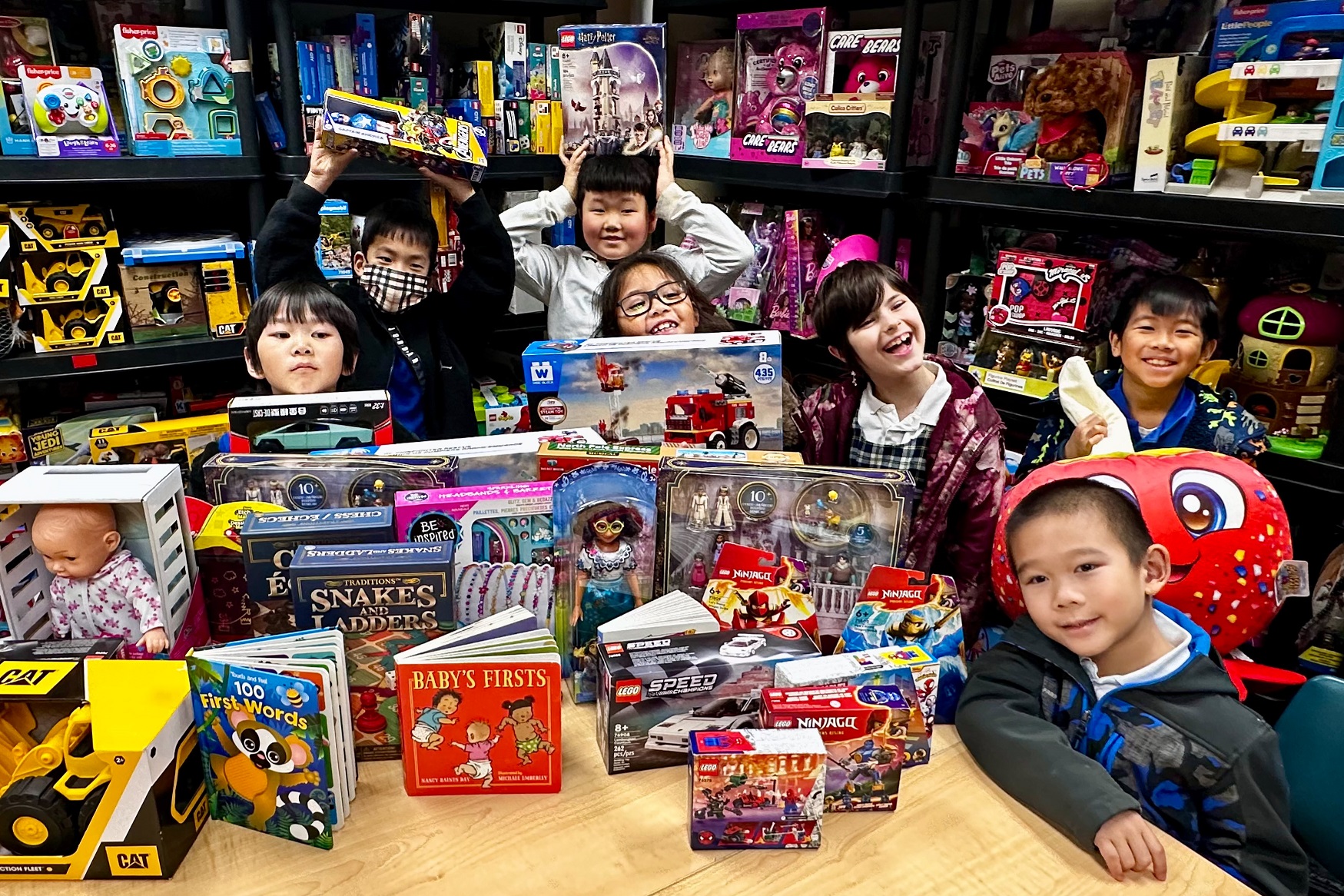 A group of smiling children surrounded by toys