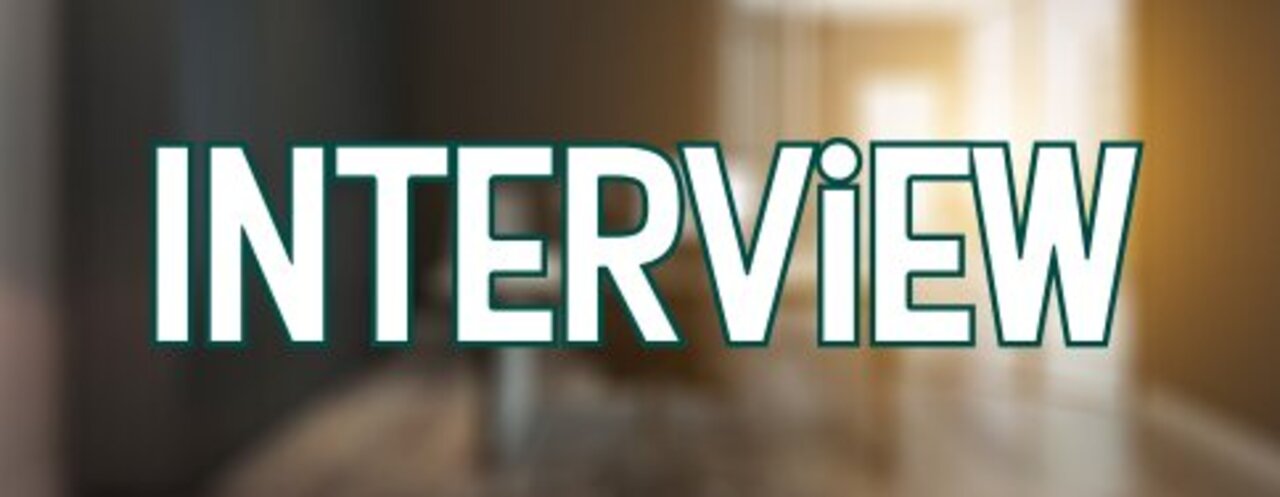 Blurred image depicts a warmly lit office space or interview room