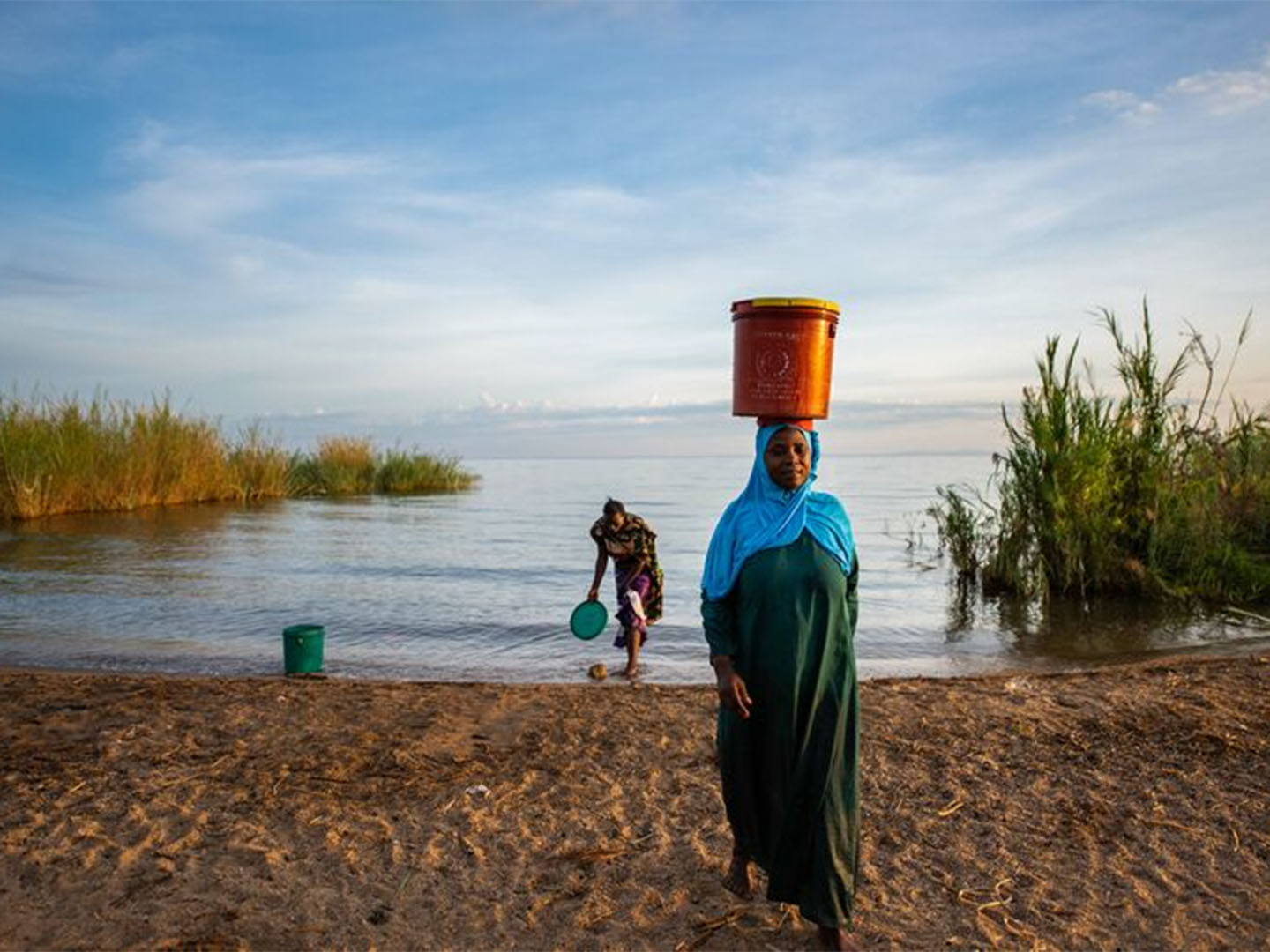 African woman carrying a bucket of water on her head. Photo courtesy of Roshni Lodhia/The Nature Conservancy.