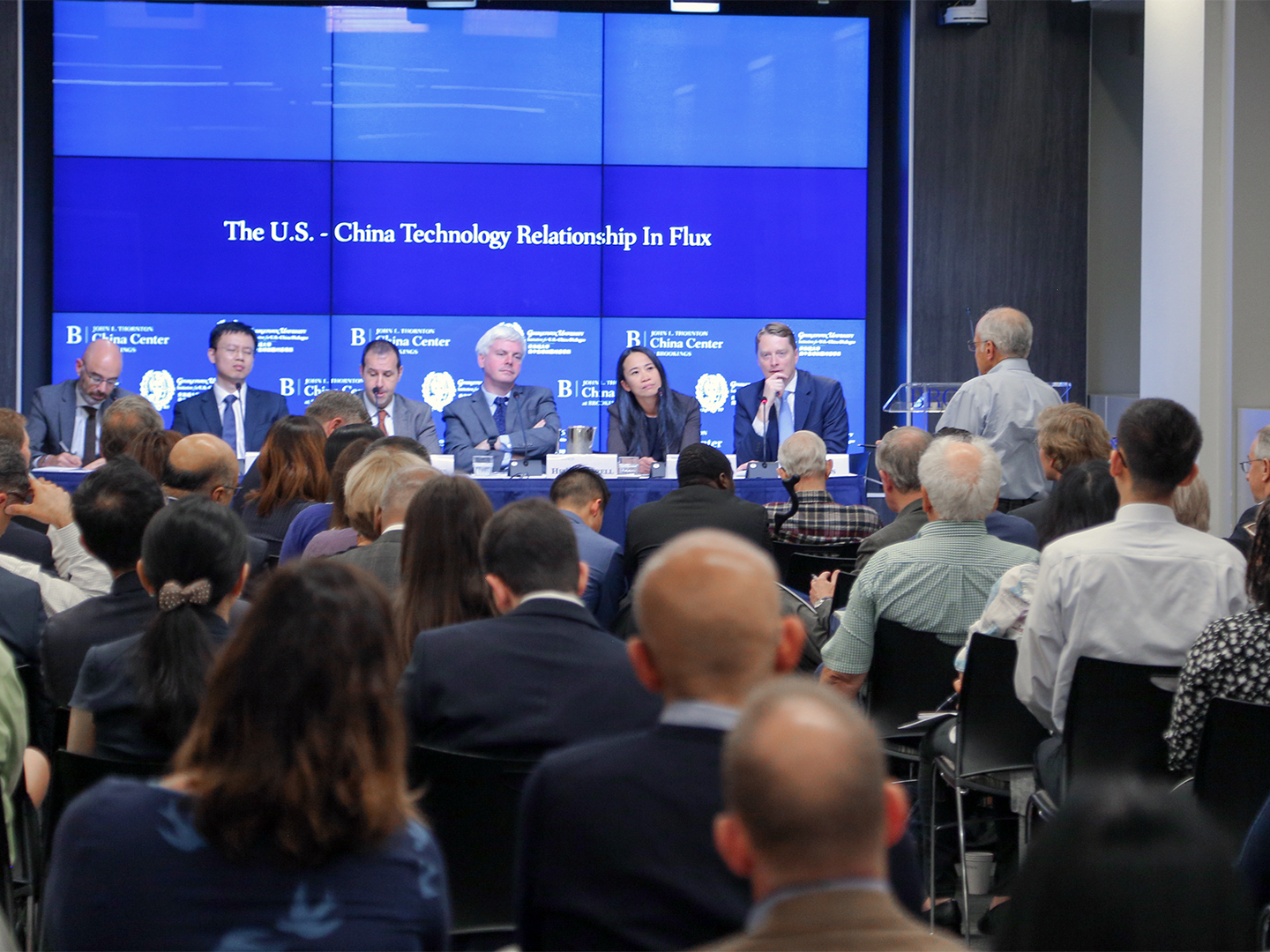 Panelists listening to an audience member ask a question