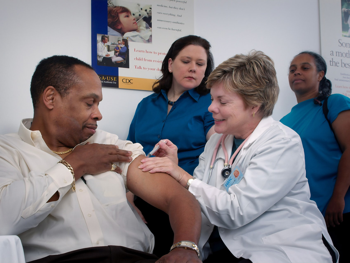 People watching a doctor give a man a shot