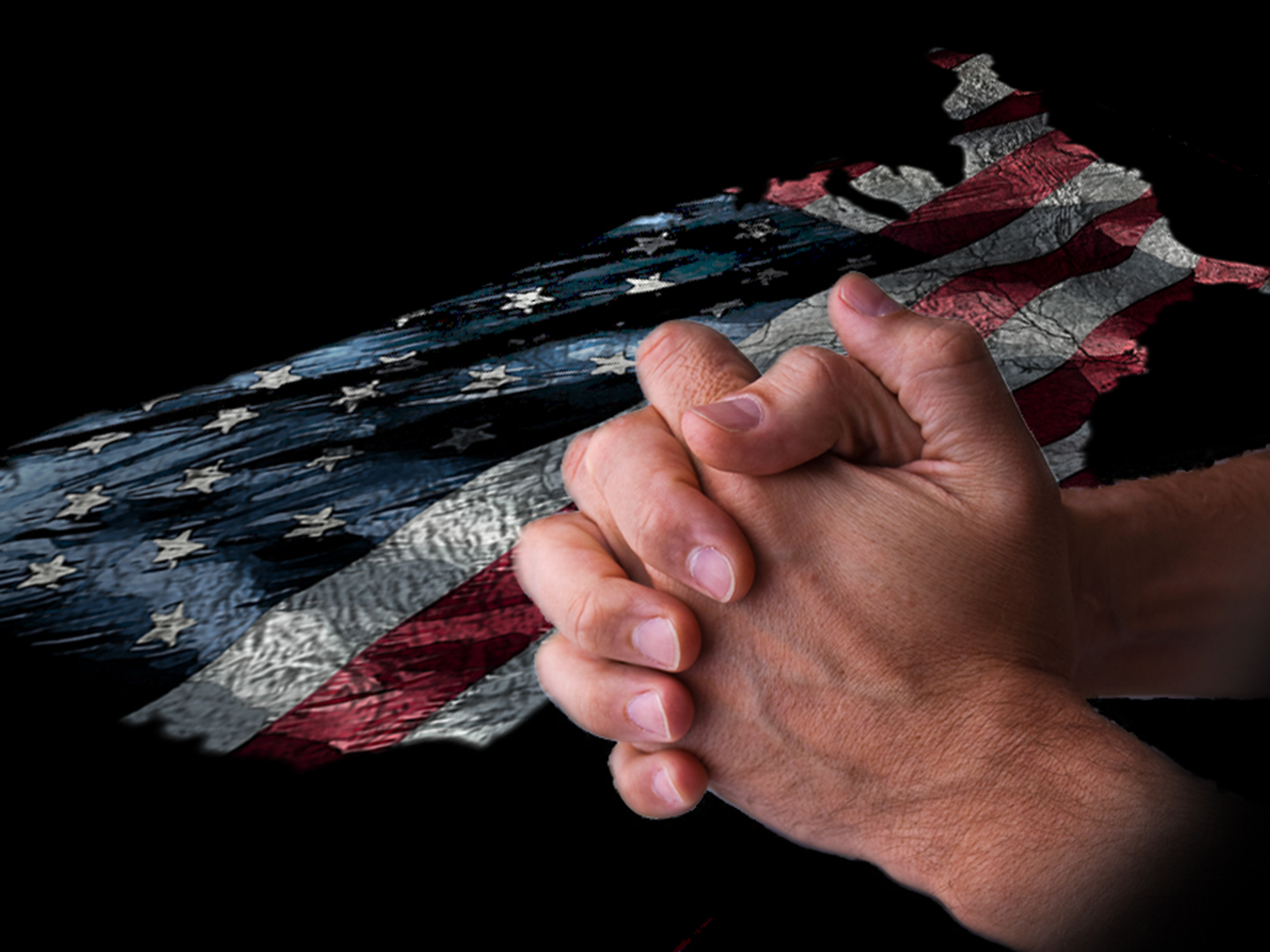 Man holding hands in prayer over USA flag background