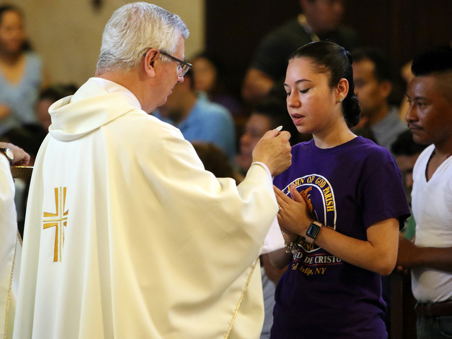 Young Latina woman receives communion