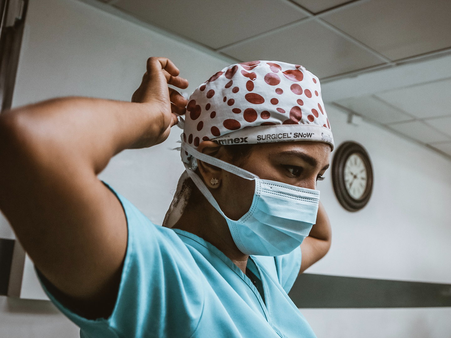 A healthcare worker putting on a face mask