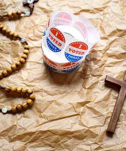 A rosary and an "I voted" sticker
