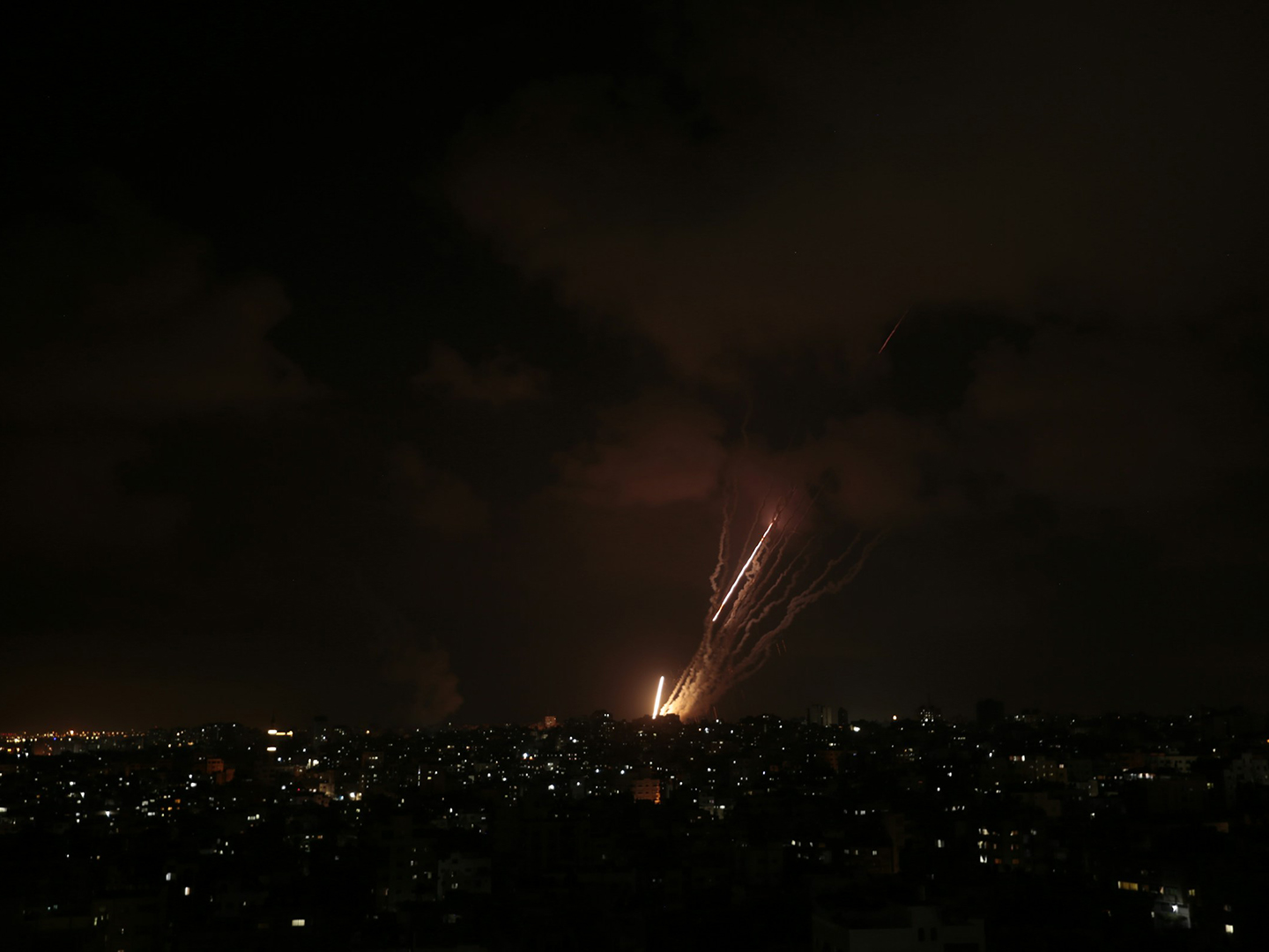A city at night with fireworks shooting fire and smoke into the air