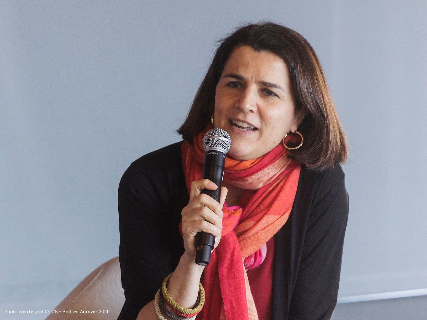 Judit Carrera speaks into a microphone at the event