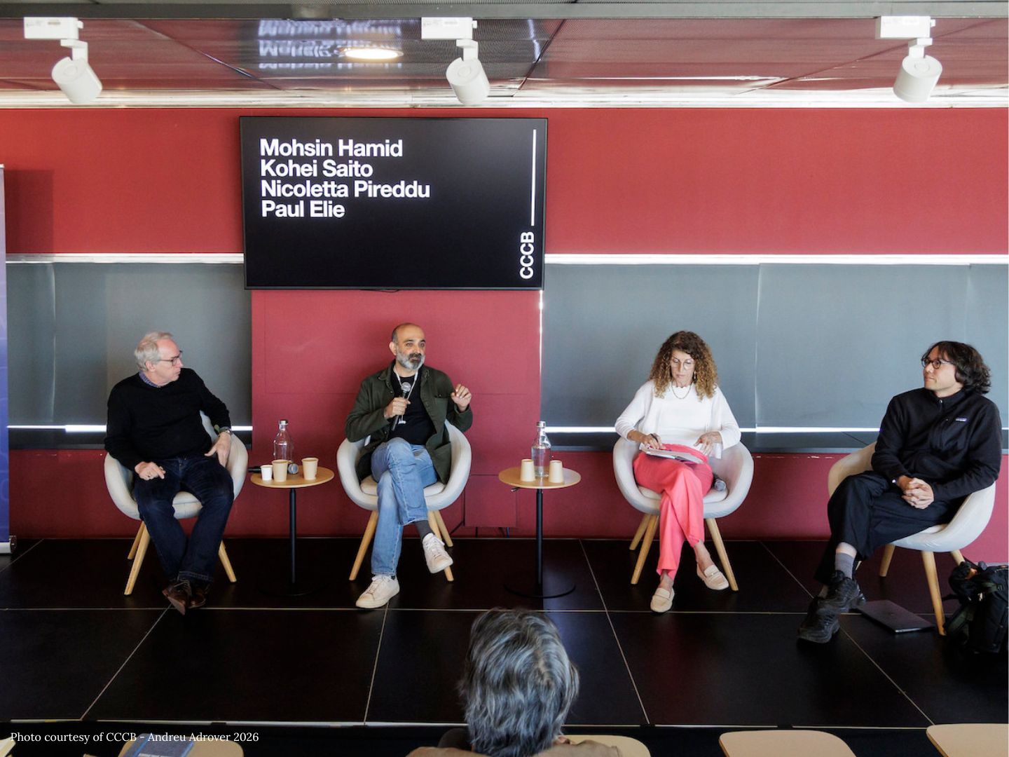 Paul Elie, Mohsin Hamid, Nicoletta Pireddu, and Kohei Saito sit in chairs on a stage