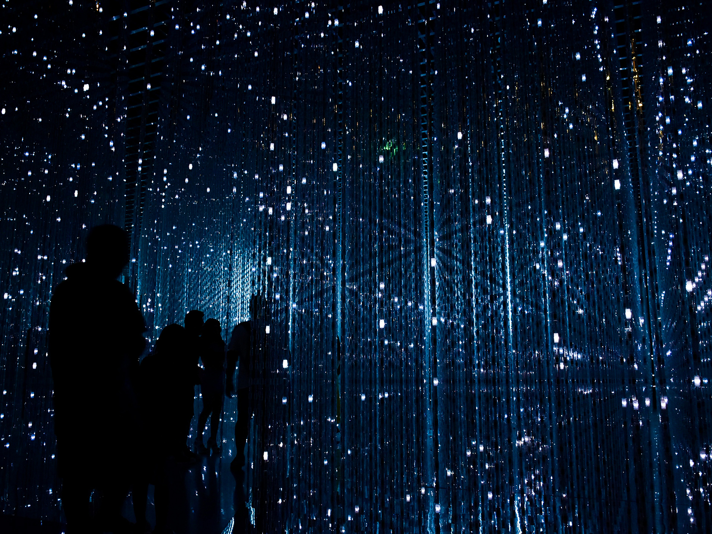 A group of people walking in a lit-up room