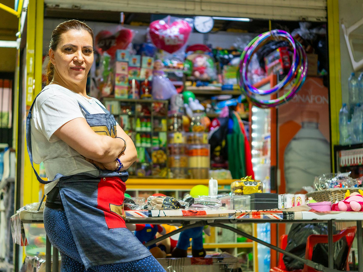 A shop owner stands in front of her shop.