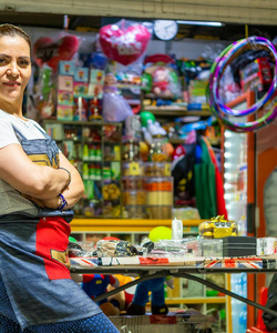 A shop owner stands in front of her shop.