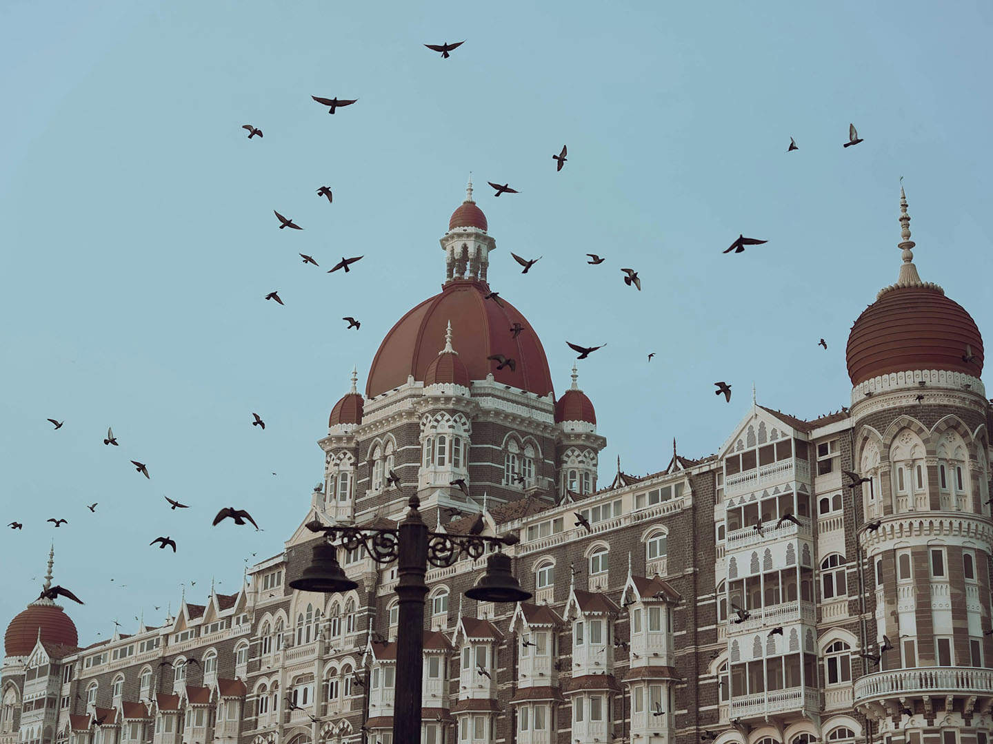 A flock of birds leaves the roof of the ornate Taj Mahal Palace in Mumbai, India