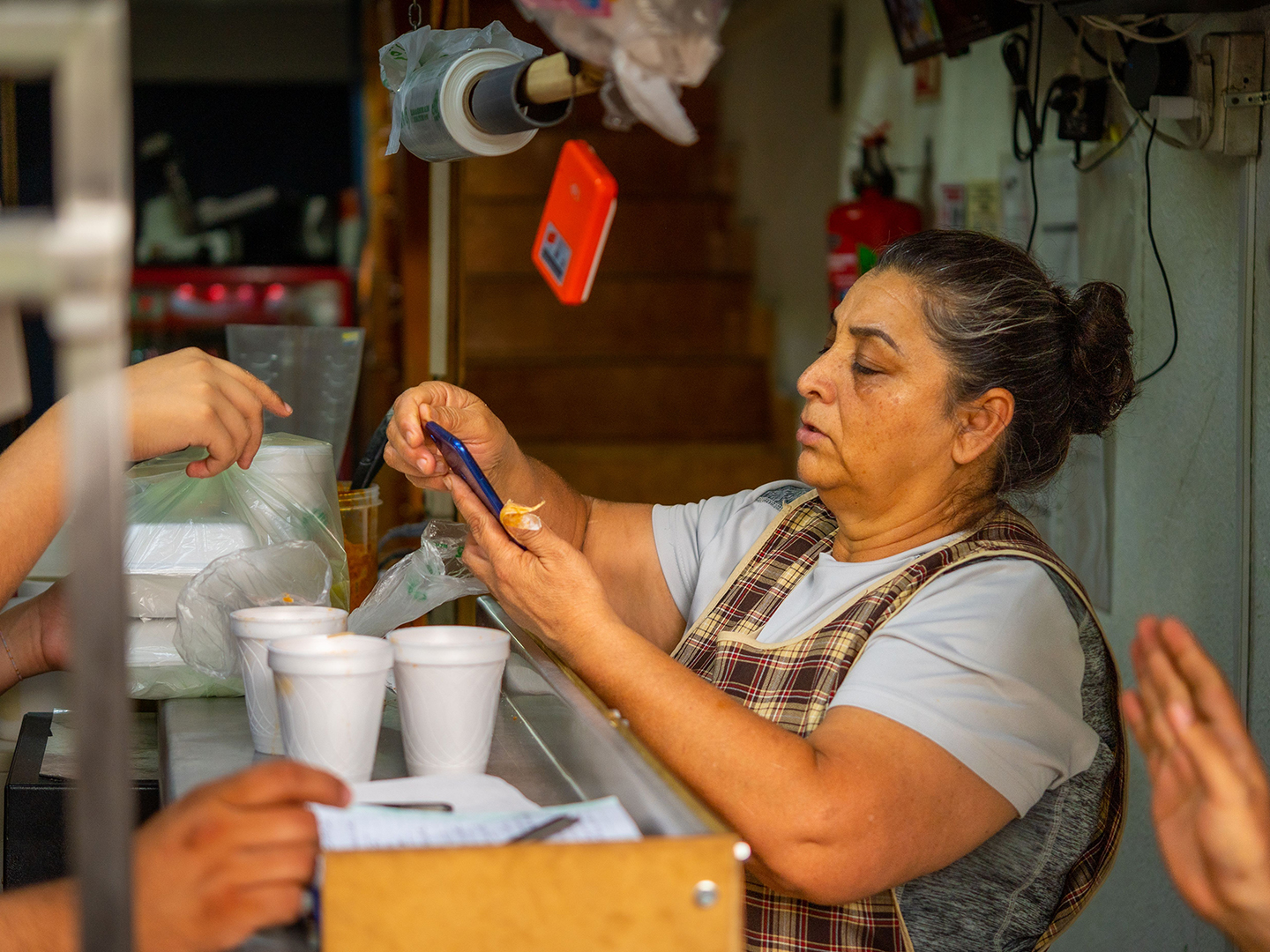 Woman takes food orders at a counter.