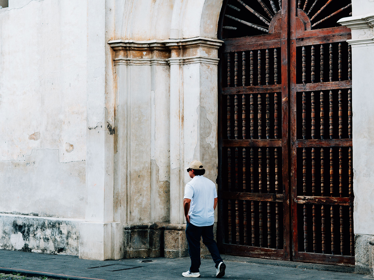 Man walking on the street past the entrance to a church
