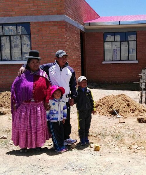 Fuller Center for Housing Bolivia beneficiaries stand with their new home
