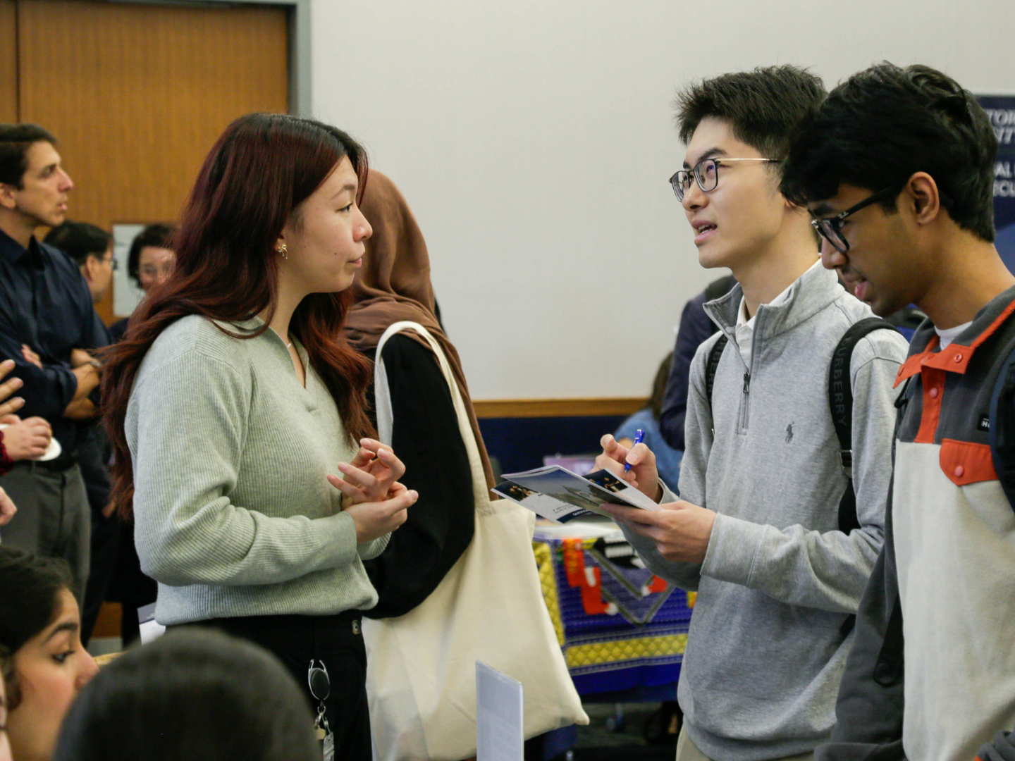 Sophie Zou, program coordinator at the Global Health Institute, speaks with a student.