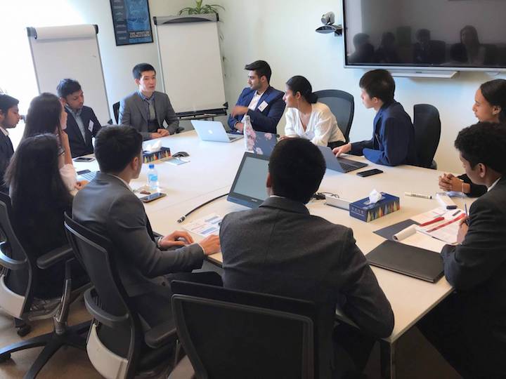 Students around a table represent different countries during the annual crisis simulation lab.