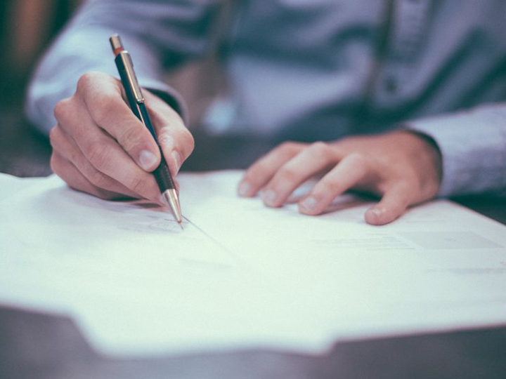 Man writing with pen and paper