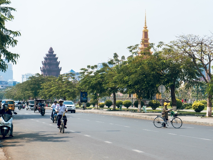Street view of Phnom Penh, Cambodia with notable Cambodian architecture in the background