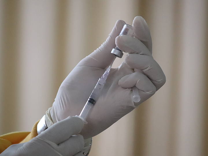 Close-up of hands preparing a vaccine