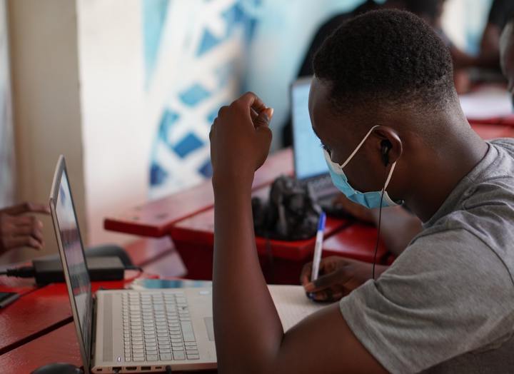 A man wearing a mask works at an internet cafe in Ghana
