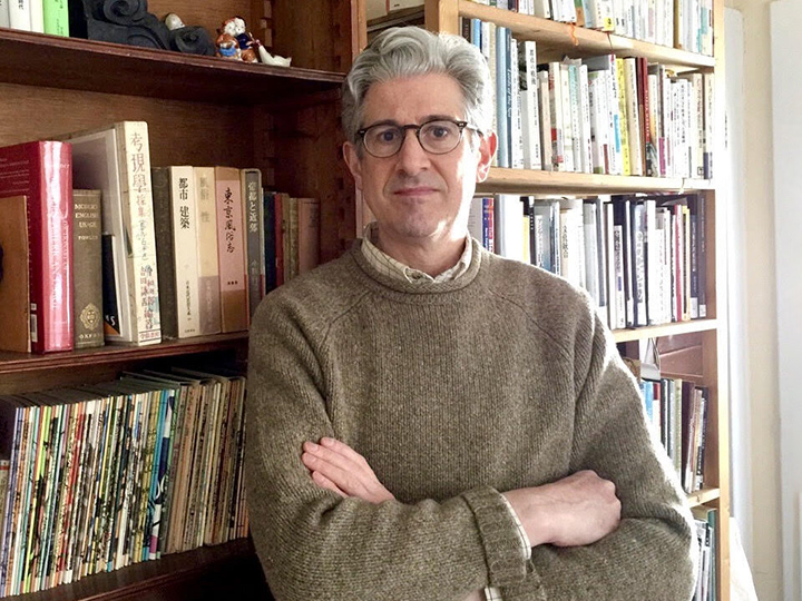 Professor Jordan Sand standing in front of a bookshelf