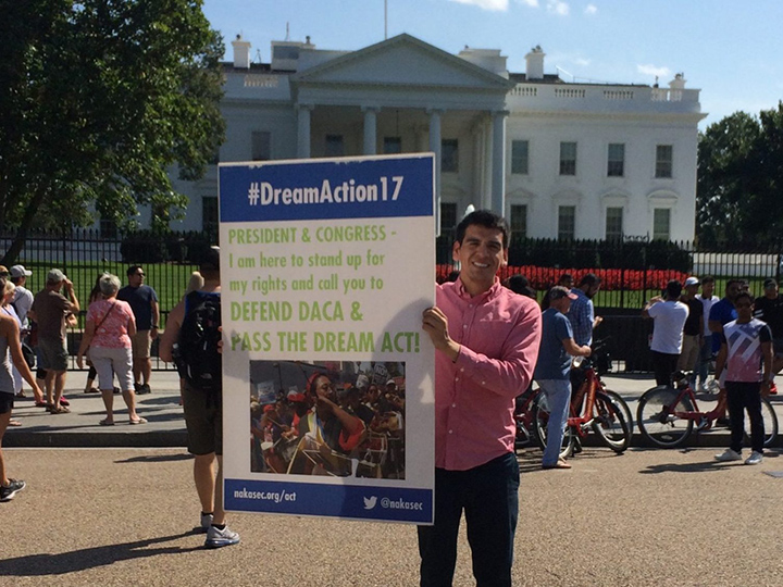 Abel Cruz Flores in front of the White House with a sign in support of DACA
