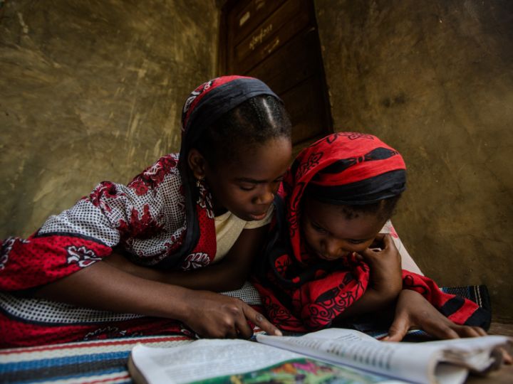Two children reading a book.