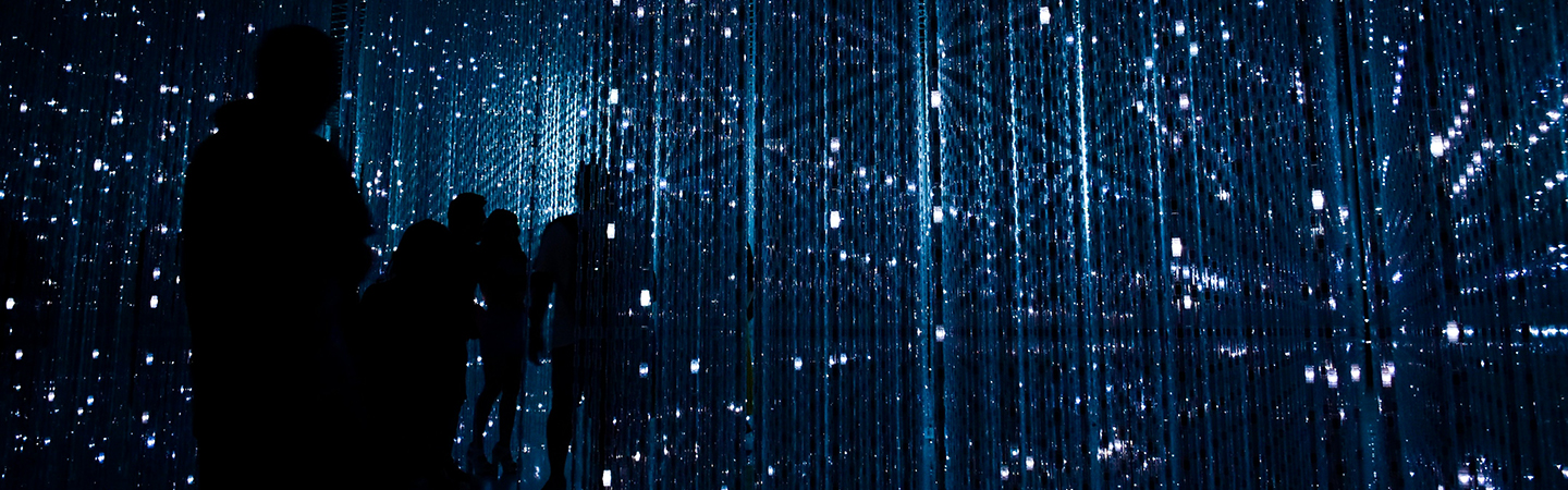 Silhouettes walking in a lit up room