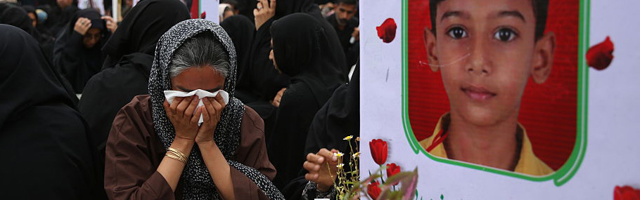 Woman cries next to a memorial for a child killed in a US Israeli attack on a primary school in Iran on March 20, 2026