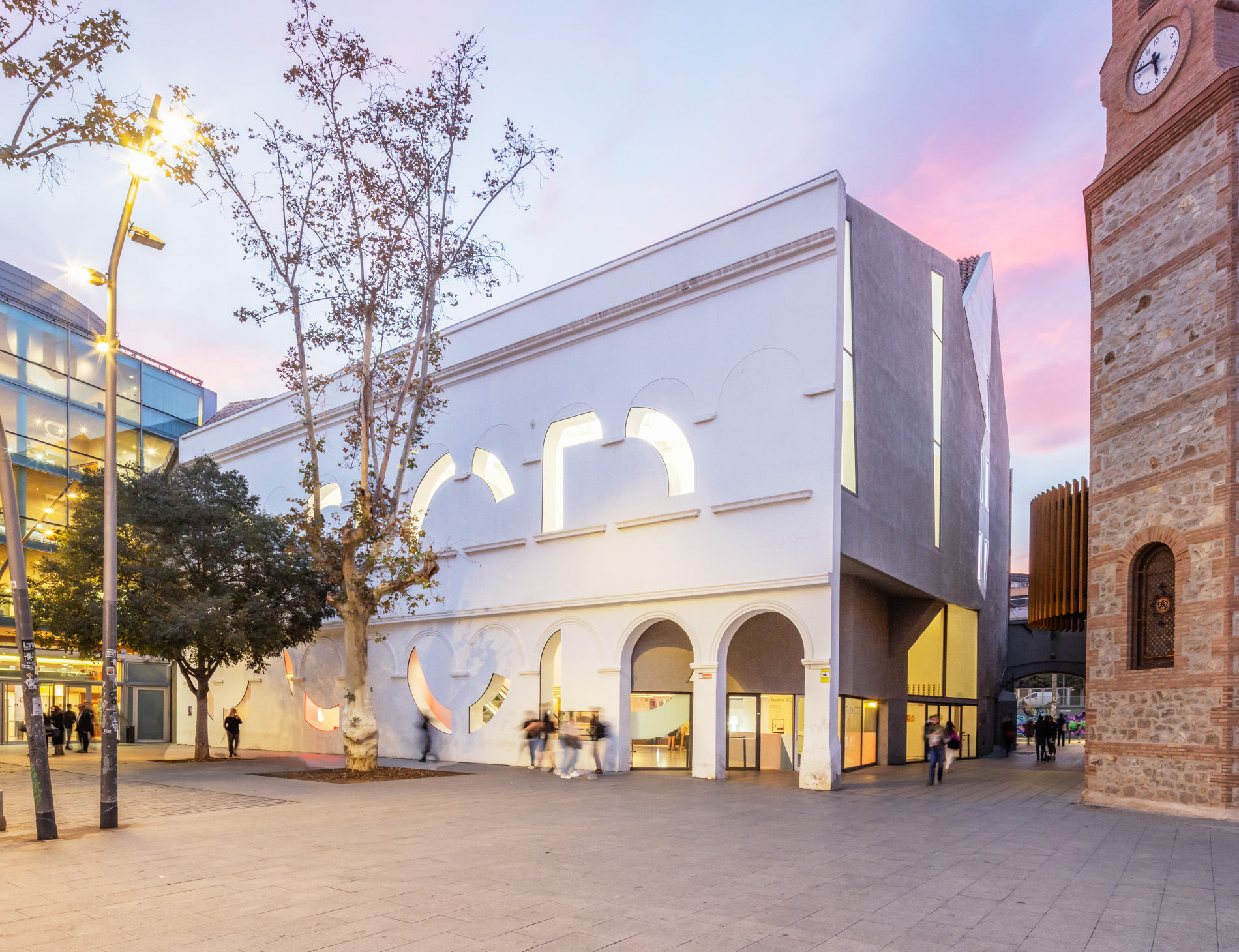White building surrounded by trees and a colorful sunset