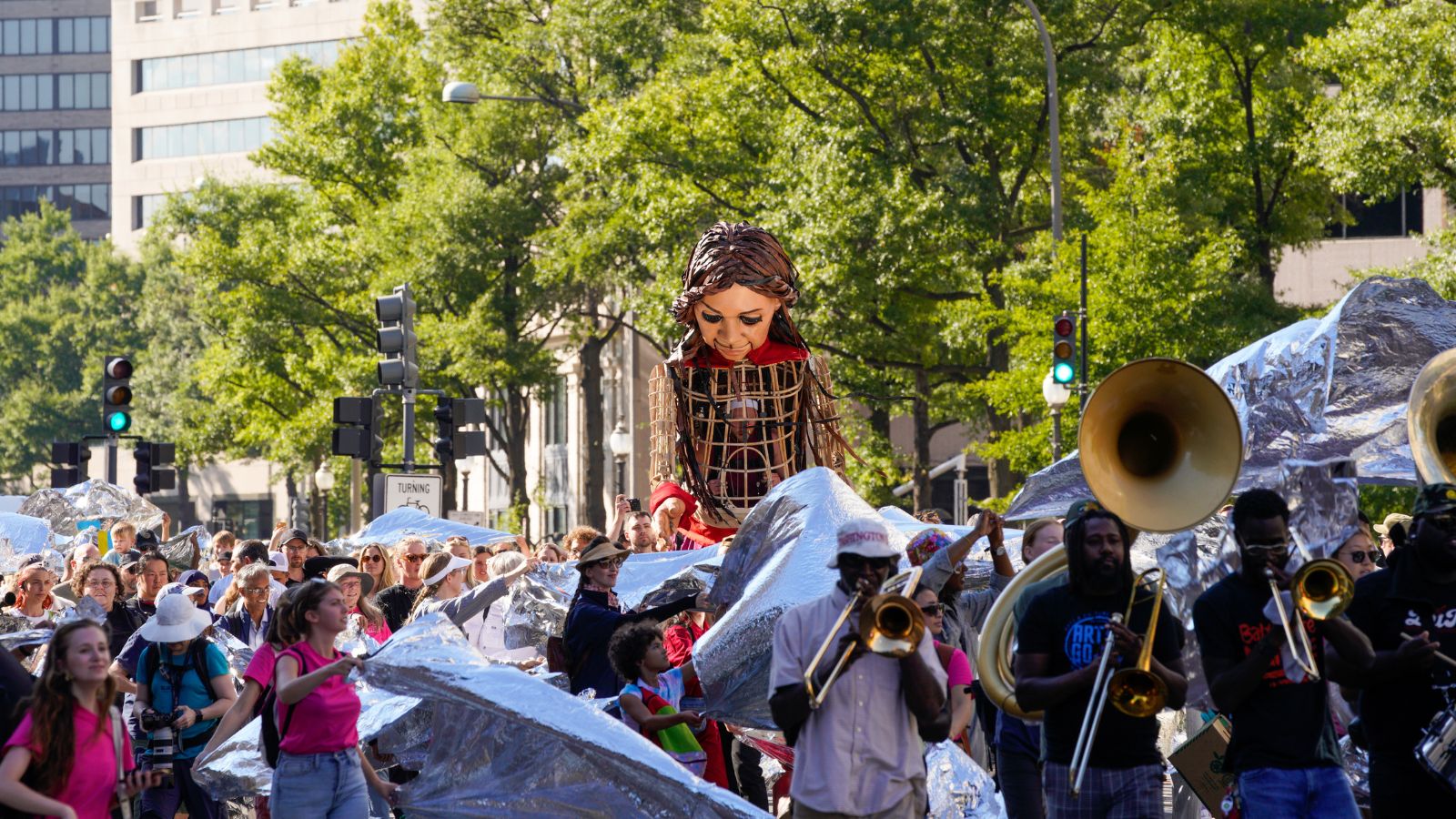 Amal processes down Pennsylvania Avenue as crowds unfurl emergency blankets.
