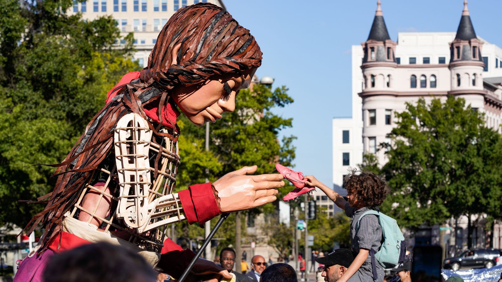 Amal takes a shoe from a child.