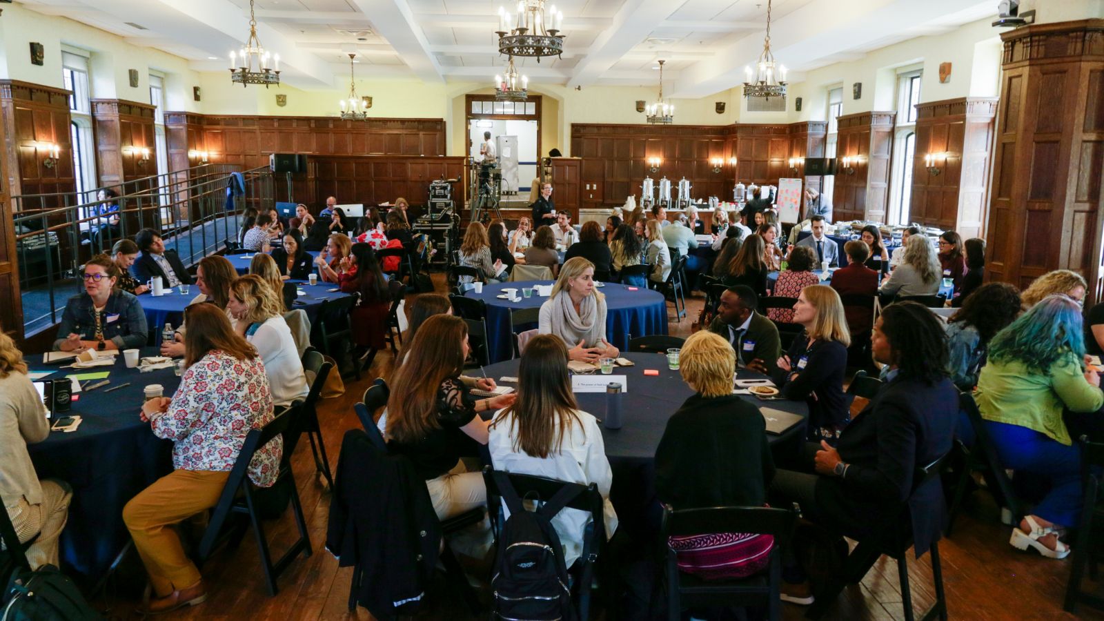 Groups of attendees of the April 24 convening sitting at round tables in a large room