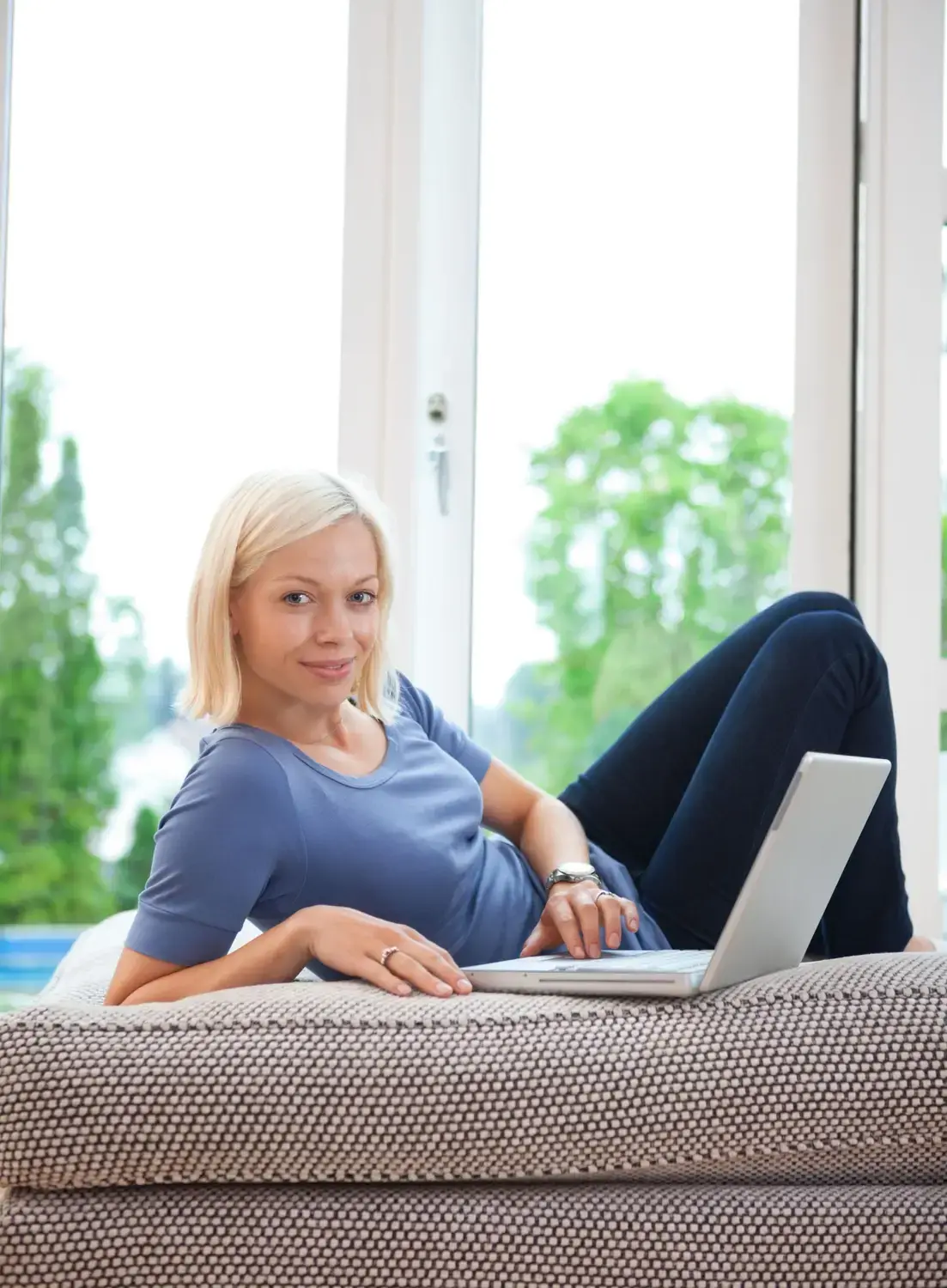 Woman enjoying a relaxed chat session on her laptop, exemplifying ease of use.
