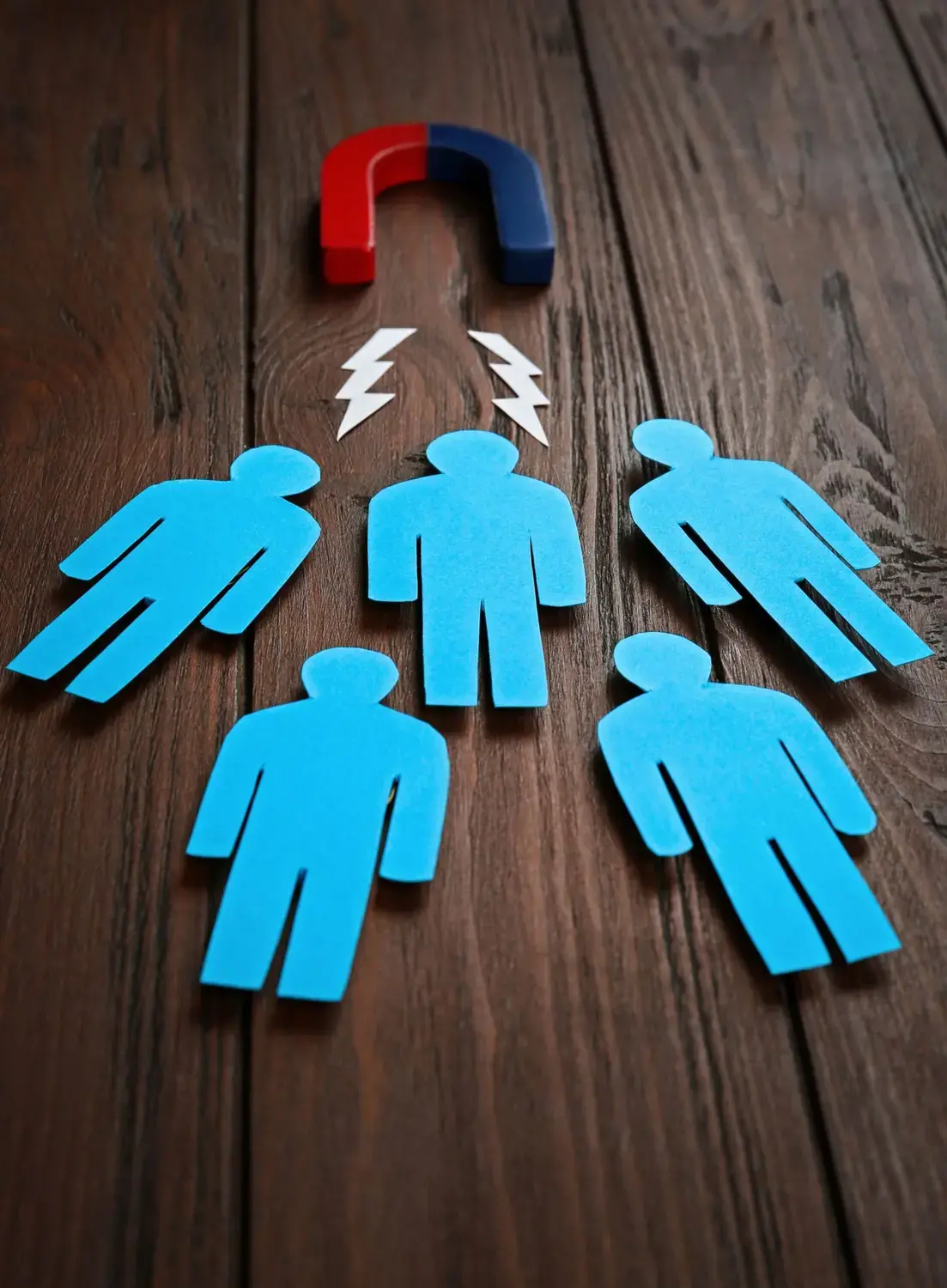 Magnet attracting paper cutouts representing leads.