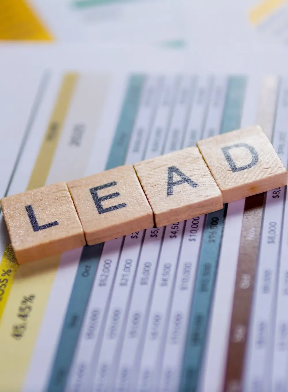 Close-up of scrabble tiles arranged to spell lead, representing the building blocks of AI-driven lead generation.