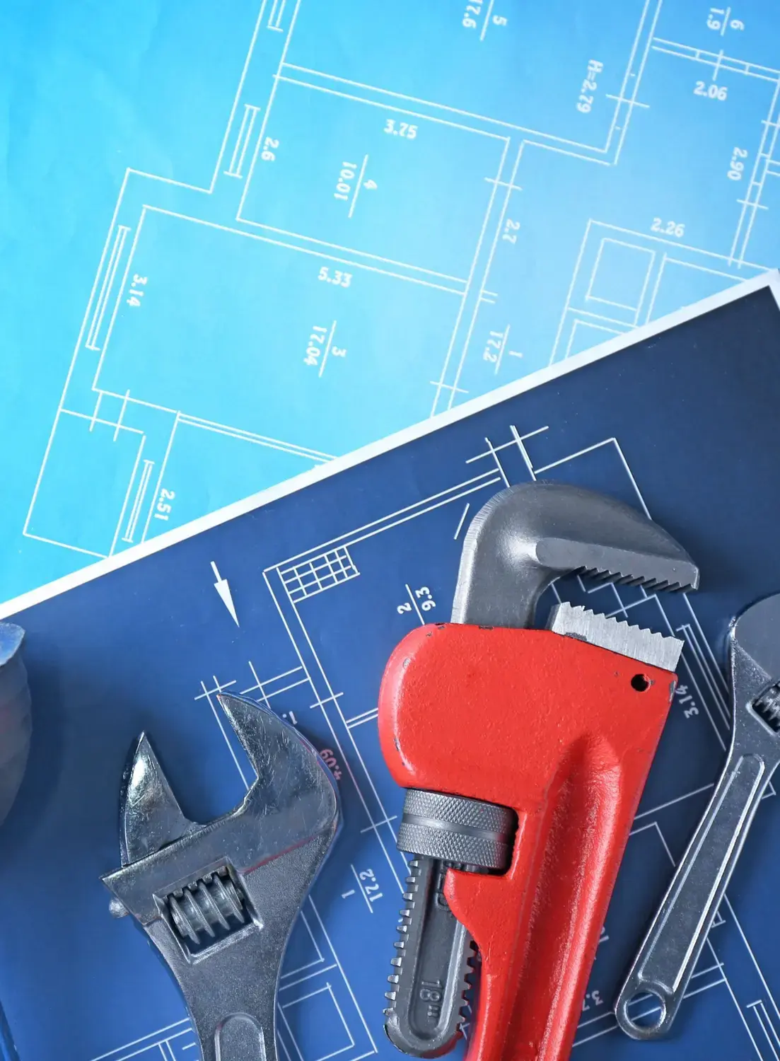 Phone beside plumbing tools, symbolizing the direct connection facilitated by the plumbing answering service.