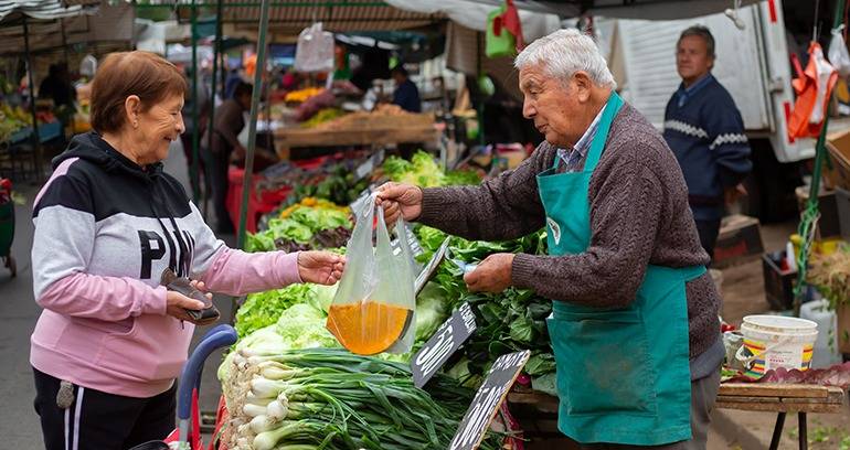 Feriante vendiendo a su cliente.